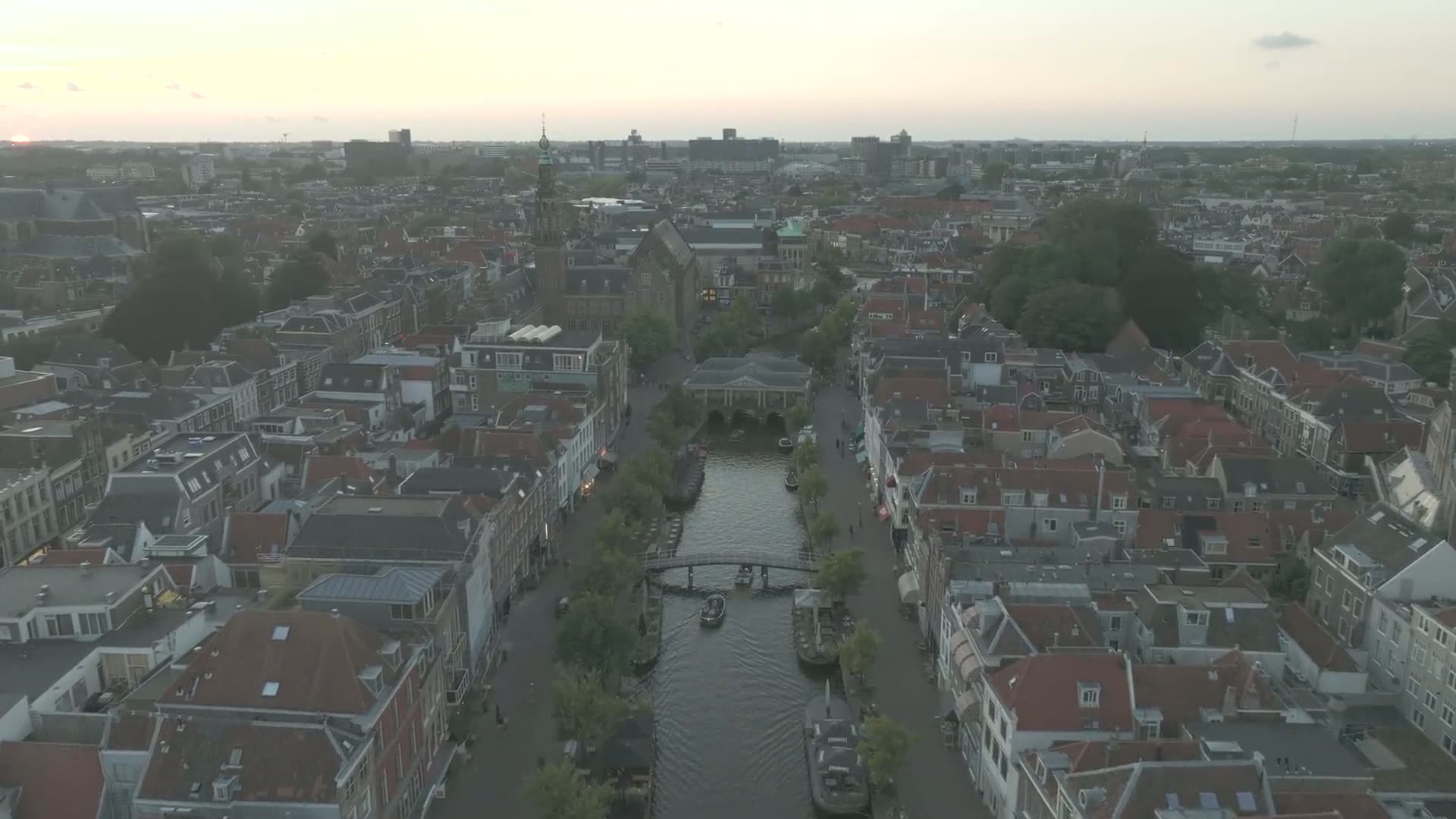 Historische Grachtenhäuser und eine Bogenbrücke in Leiden im Abendlicht